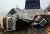 Toppled trucks and crushed van on deck