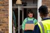 Courier and customer on doorstep urban