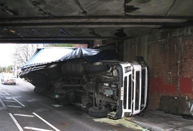 truck on side under bridge