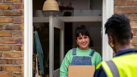 Courier and customer on doorstep urban