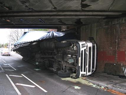 truck on side under bridge