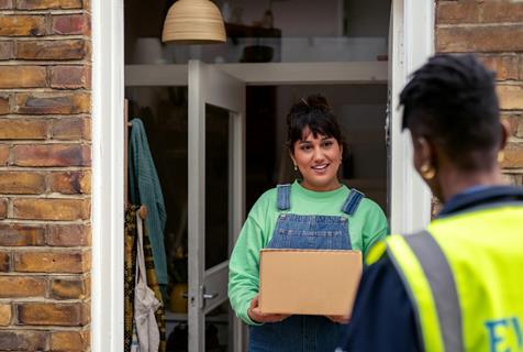 Courier and customer on doorstep urban