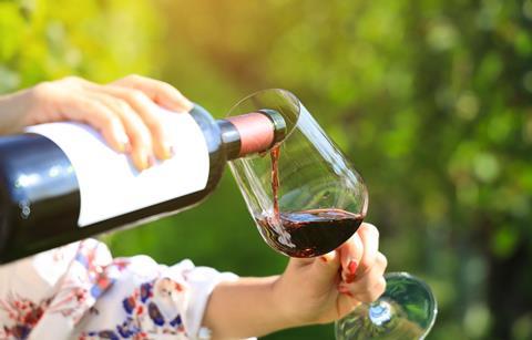Selective focus of woman hand Pouring red wine in the garden and party