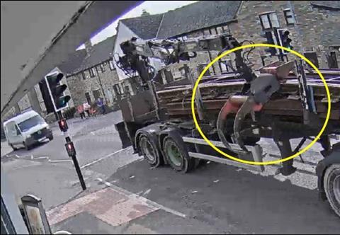 The lorry driving in Willingham after the collision with the grab crane overhanging.