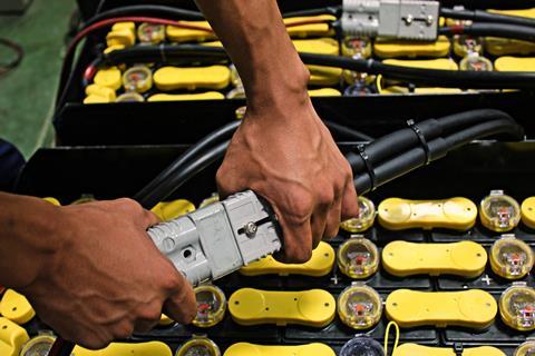 Employees,Are,Plugged,In,The,Battery,For,The,Electric,Forklift.